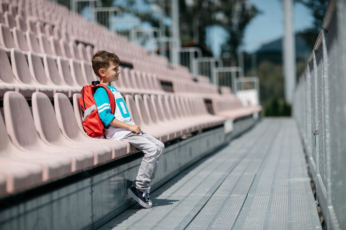Portrait of a schoolboy with a bag taking a break from school